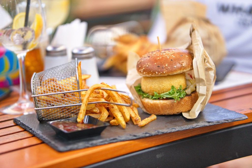 Burger cu chiflă cu semințe, cartofi prăjiți și sos