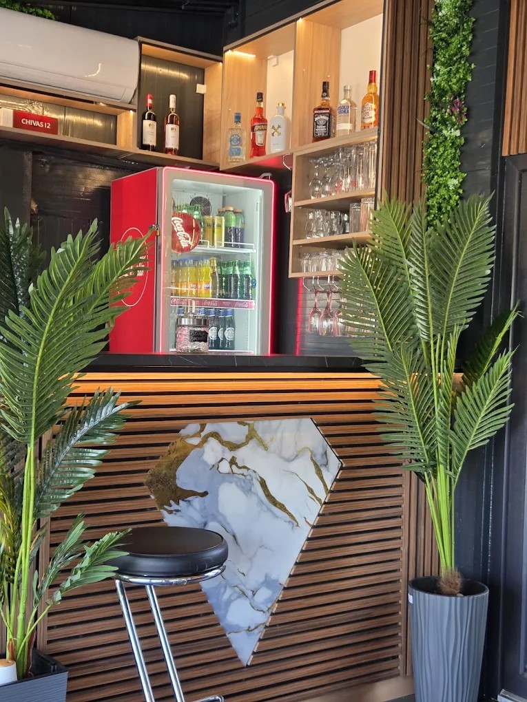 Barul Jungle Bistro, cu blat de lemn, marmură și sticle la raft