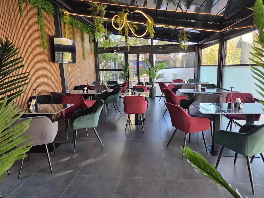 Lounge cu masă de marmură, lampă de masă și vegetație pe tavan