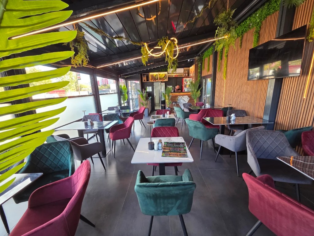 Sala Jungle Bistro: fotolii verde, bordo și gri, plante și neon